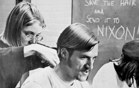 Archival image of a student cutting another student's hair in 1970.