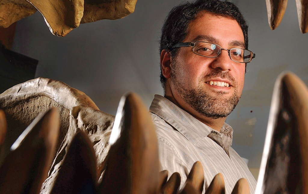 Matthew Carrano &rsquo;91 grins alongside some dinosaur teeth