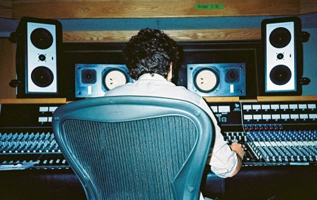 JJ Wiesler sitting back-to the camera at a soundboard.