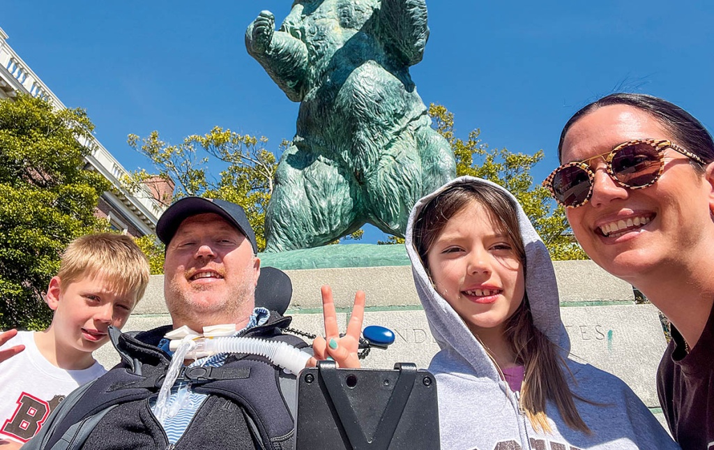 Close-up image of Nate Poole and family in front of Bronze Bruno on Brown University Campus