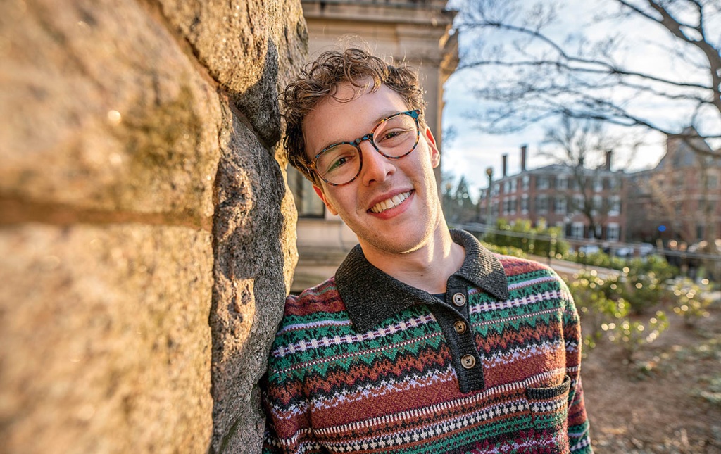 Image of Myles Ringel leading his head against a brick wall.